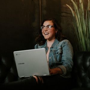 Photo of woman smiling behind computer